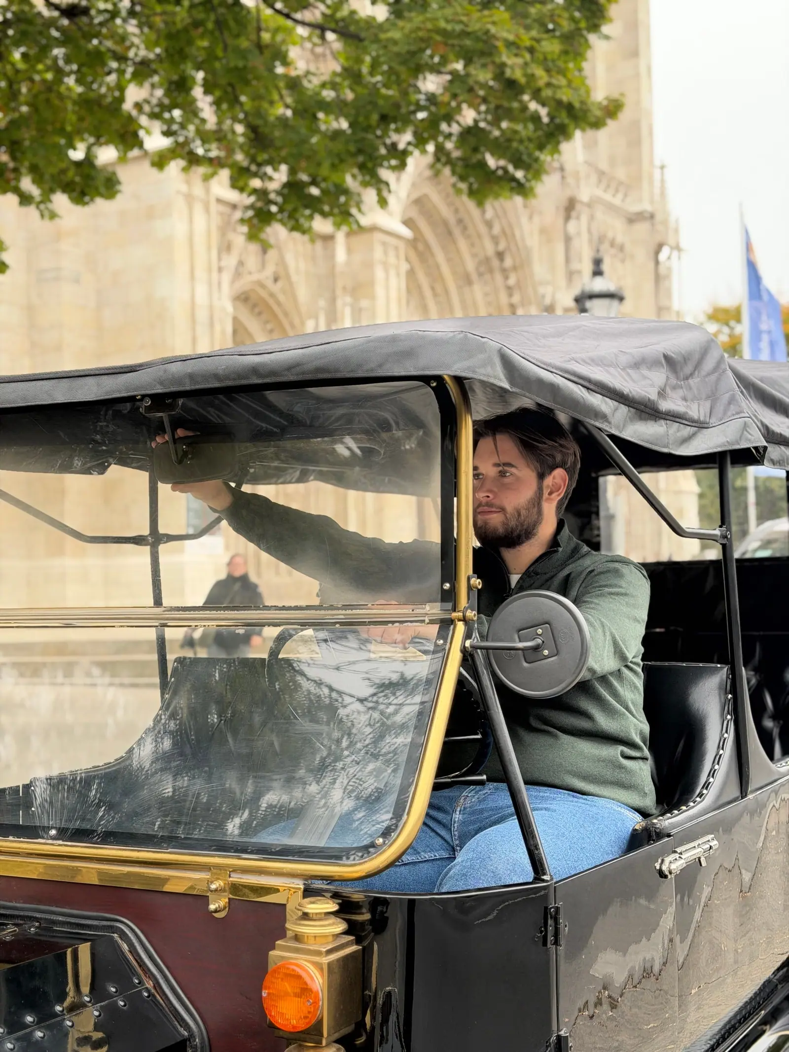 The driver at the wheel of the open vintage car